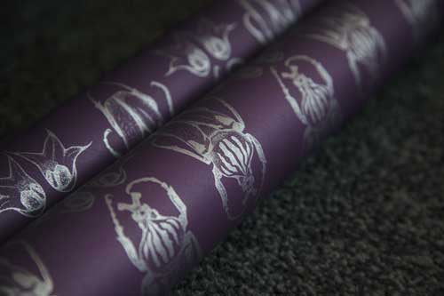 Beetle wallpaper, silver beetle illustration pattern on a royal purple background, showing the shimmering of the silver print