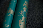 A roll of entomology inspired wallpaper with silver cicadas against a blue background