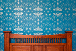 Cicada wallpaper with silver cicadas and other bugs on a blue background showcased on a bedroom wall